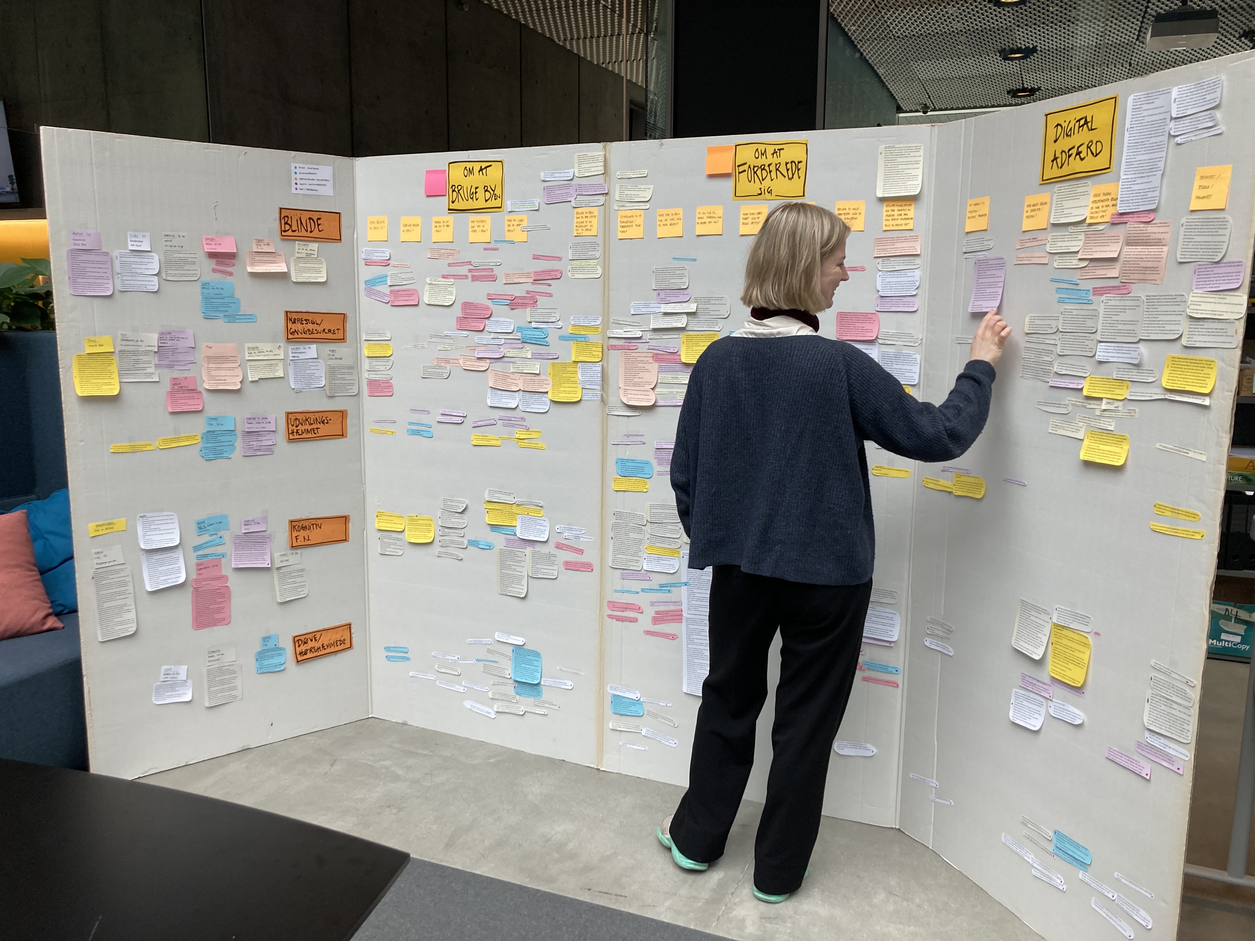 Person står også kigger på data på en projektvæg af pap